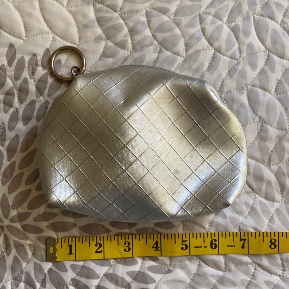 Silver small clutch with ring detail on zipper.